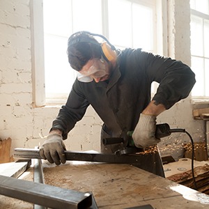 Worker grinding steel in workshop