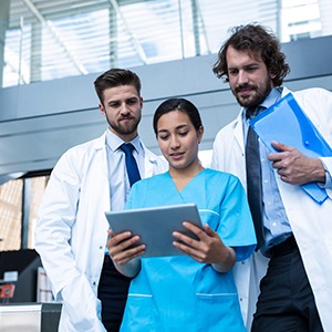 doctors looking at nurse with tablet diagnosis