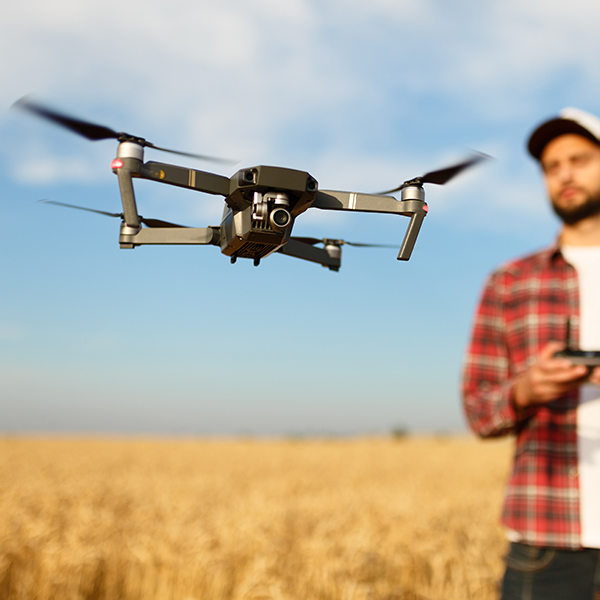 Man flying drone in agricultural field