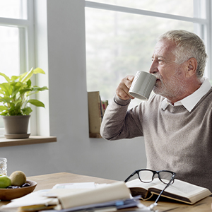 Senior man drinking coffee in his house