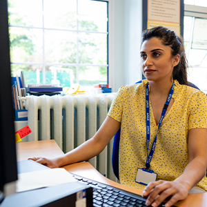 Teacher woman looking at computer in a school