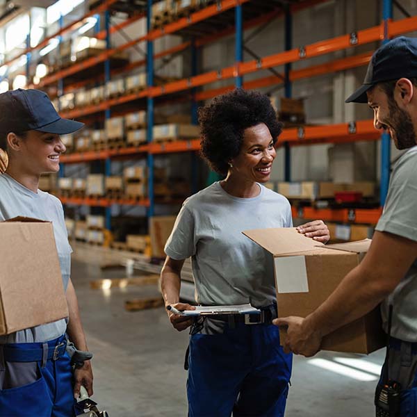 Group of multiethnic workers in a warehouse looking over packages